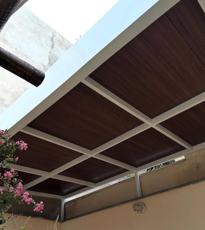 Cobertura metálica branca com forro de madeira em área residencial